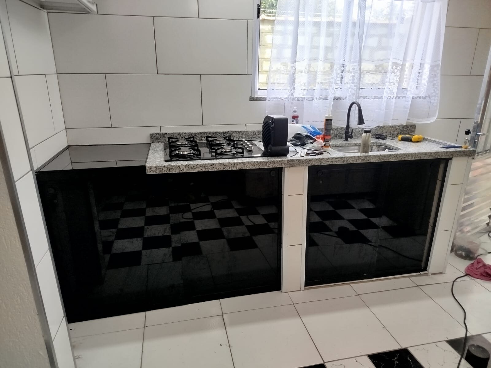 Fechamento de pia em vidro preto com acabamento alinhado à bancada