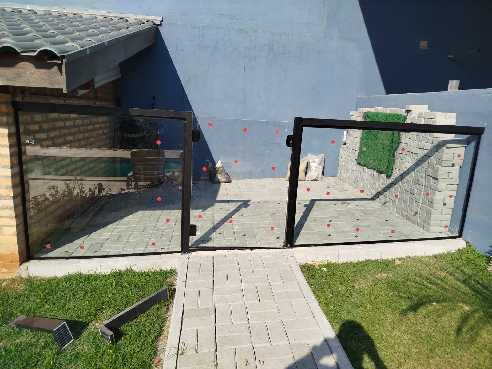 Guarda-corpo e portão de vidro em área externa residencial