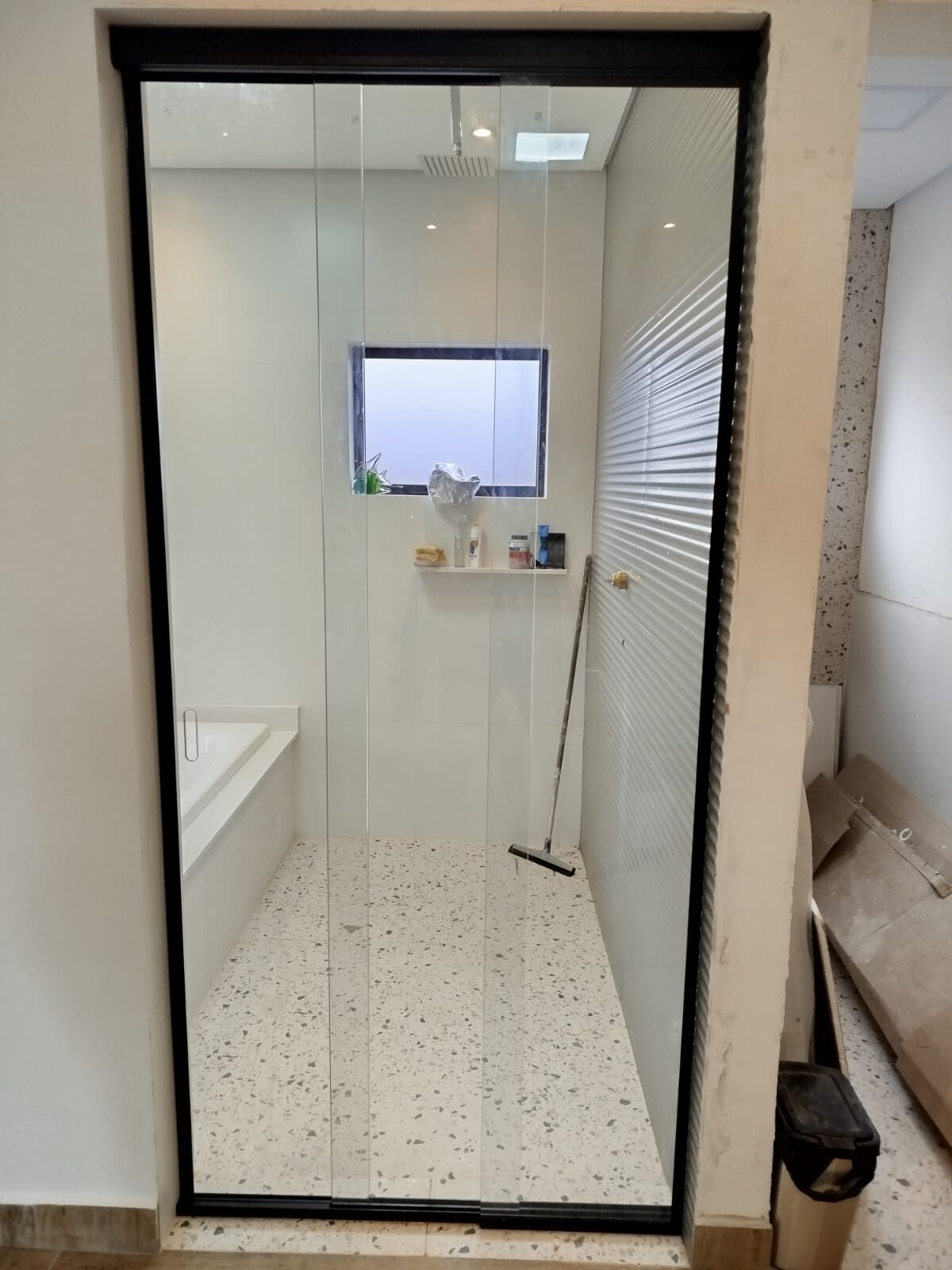 Box de vidro com perfil preto instalado em banheiro reformado