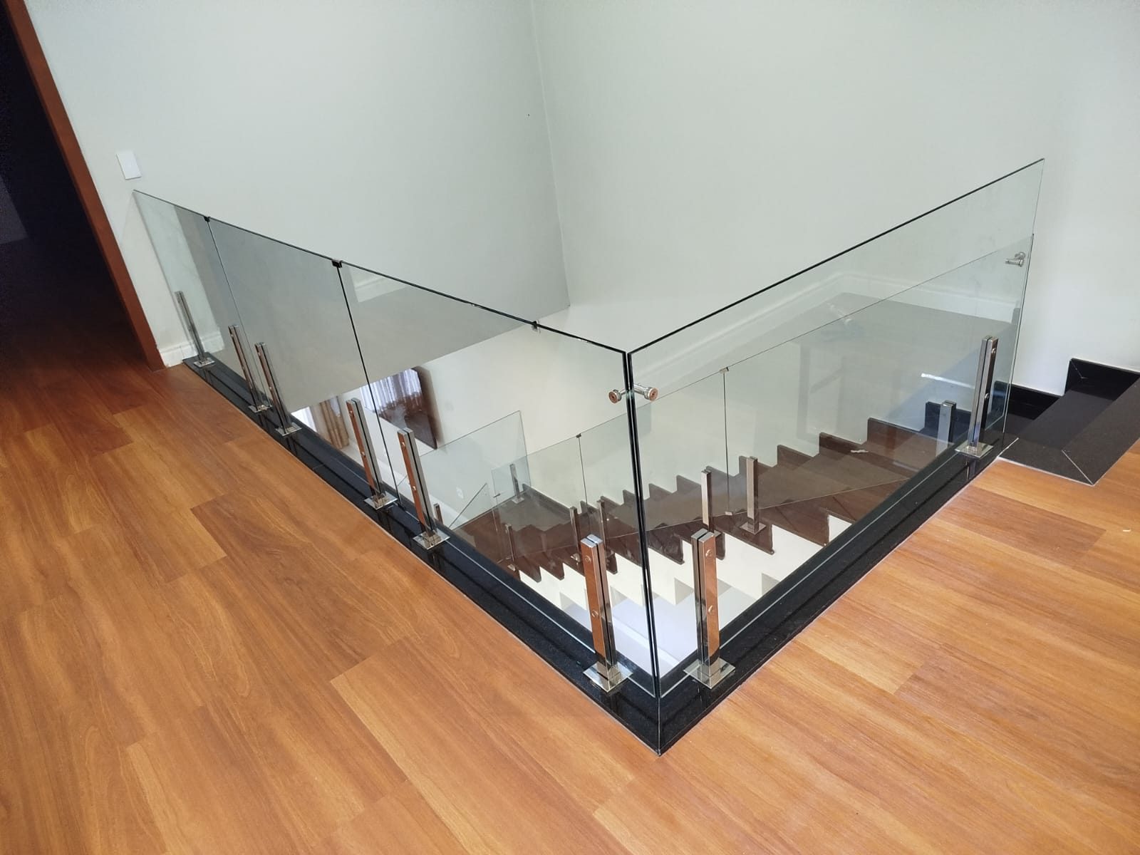Guarda-corpo de vidro com fixadores em piso de madeira