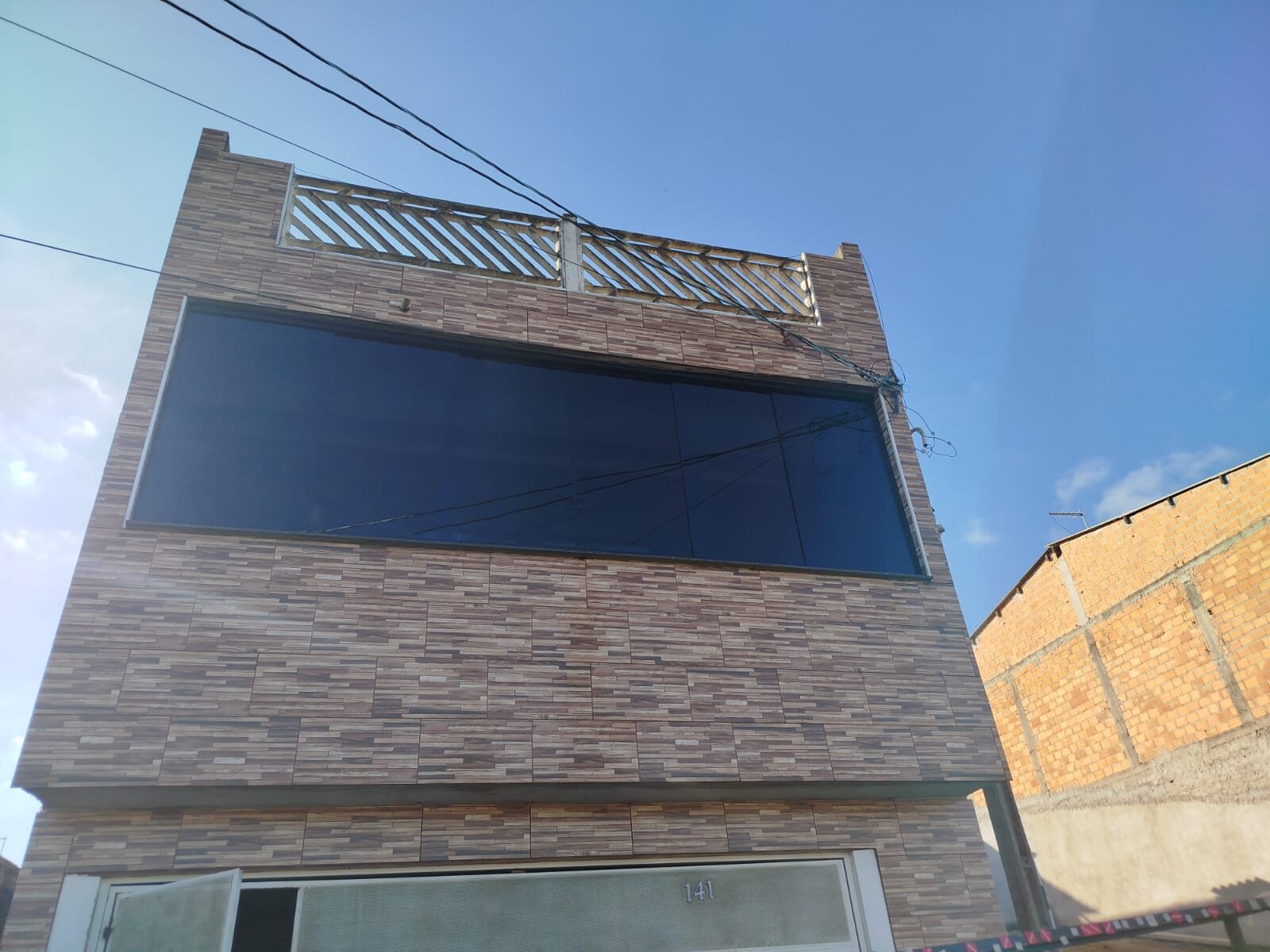 Fachada residencial com fechamento em vidro azul
