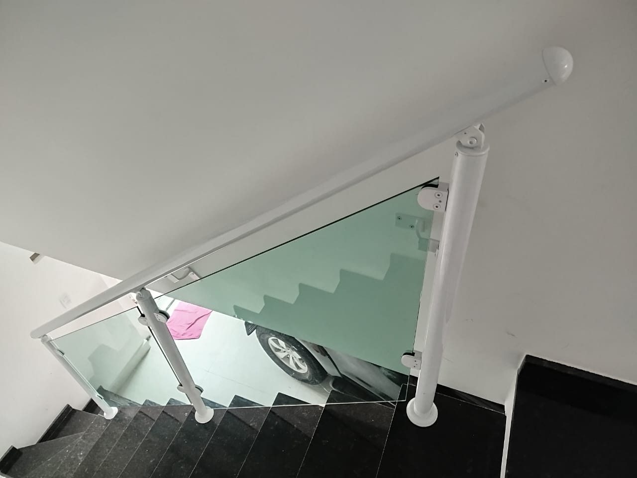Guarda-corpo de vidro com corrimão branco em escada externa