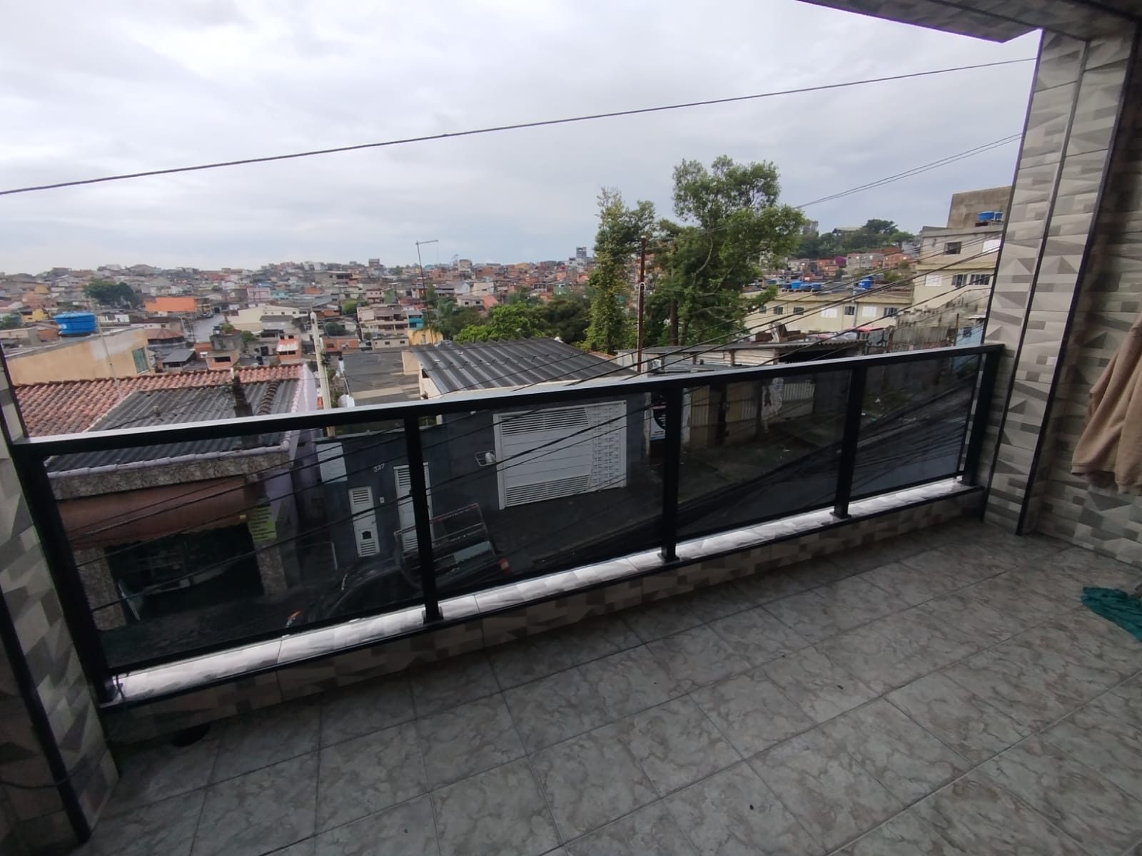 Guarda-corpo de vidro em sacada ampla com perfis de alumínio