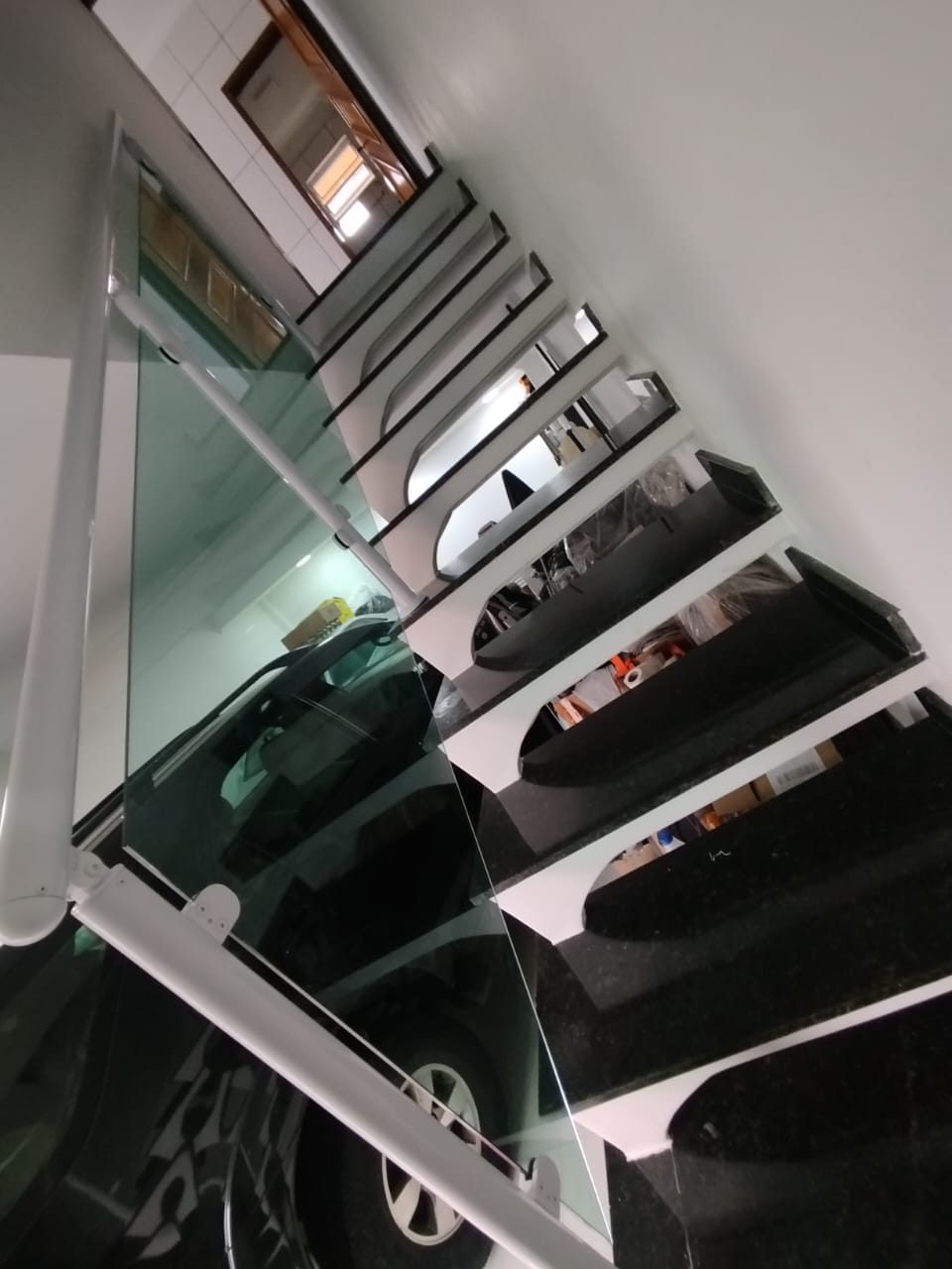 Guarda-corpo de vidro em escada externa com vista para a garagem