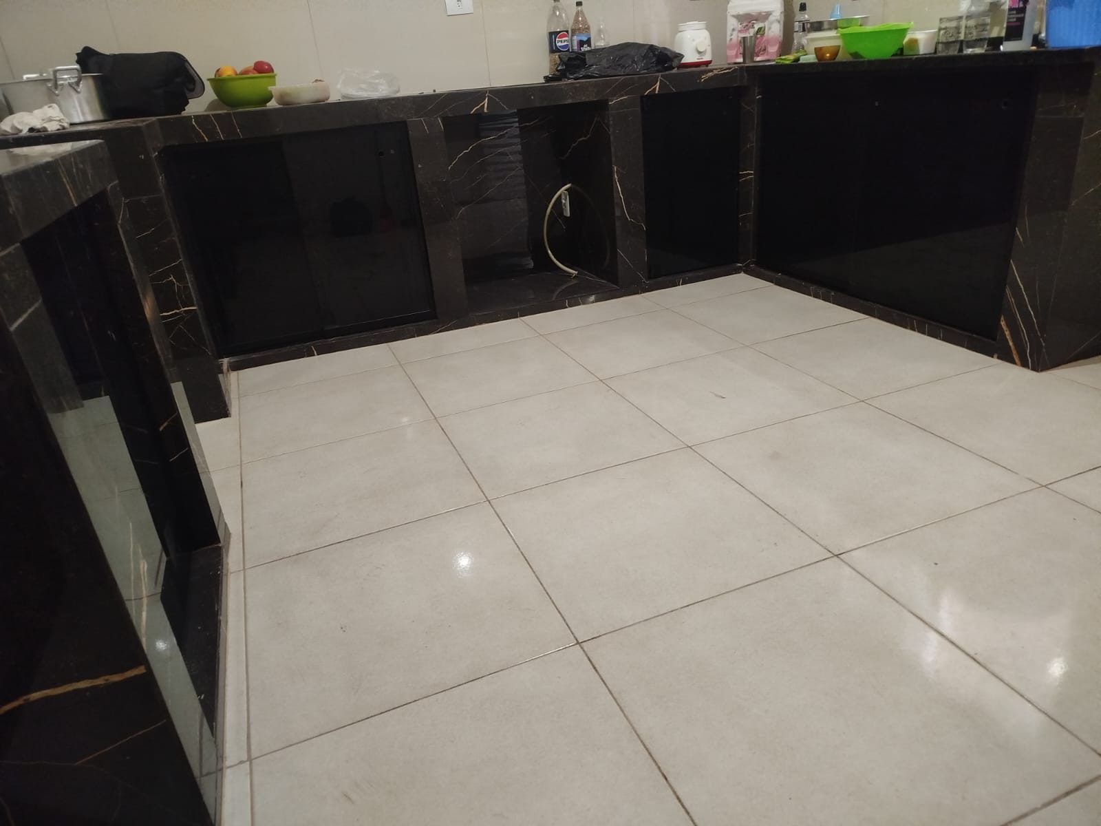 Fechamento de pia e bancada em vidro preto em cozinha ampla