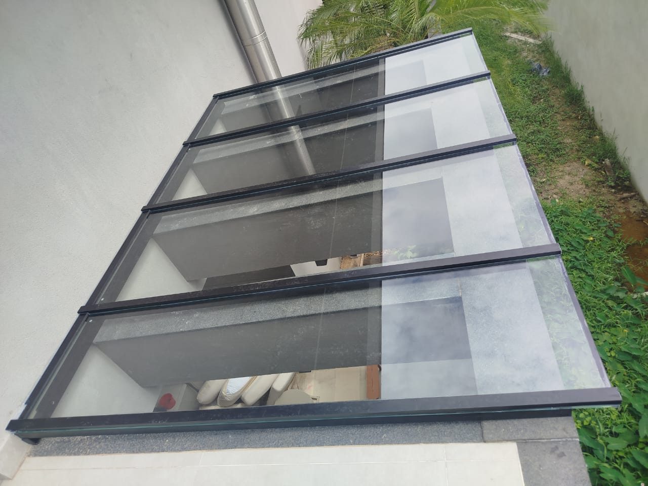 Cobertura de vidro inclinada com perfis de alumínio em área externa