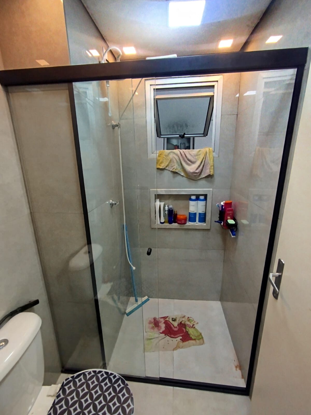 Box de vidro em banheiro residencial com nichos
