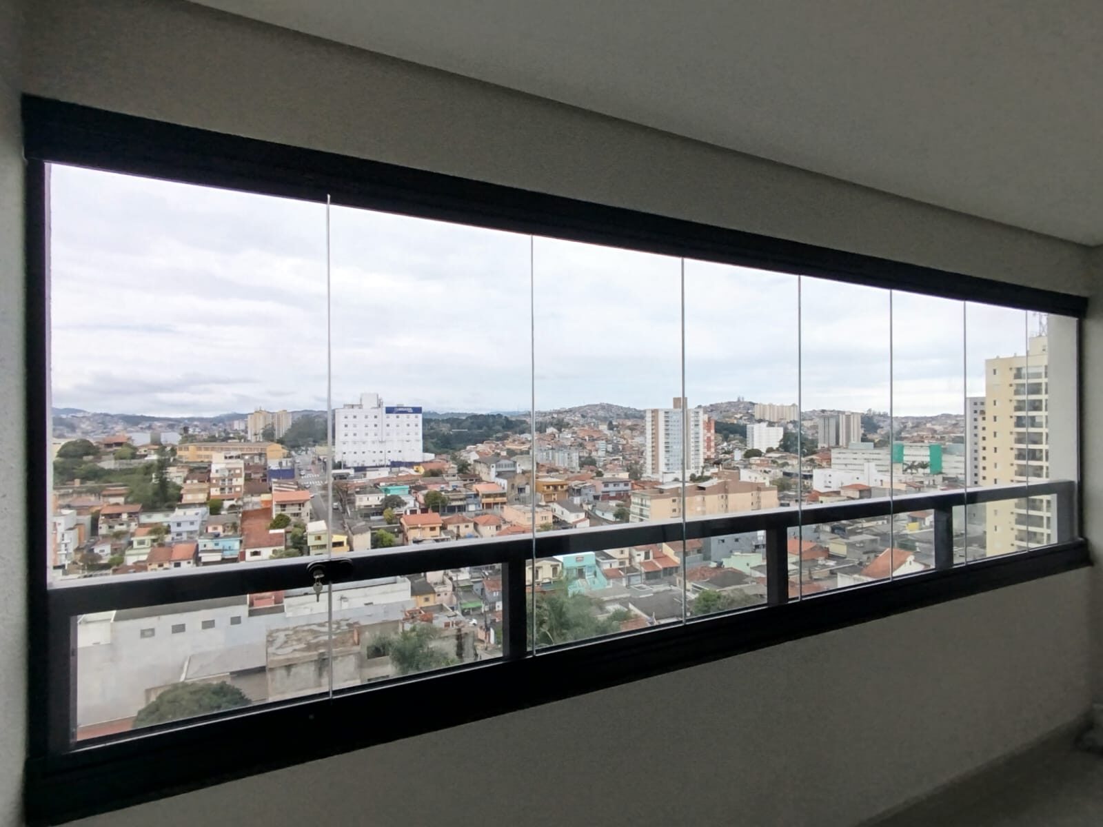 Sacada envidraçada com vidro e alumínio e vista da cidade