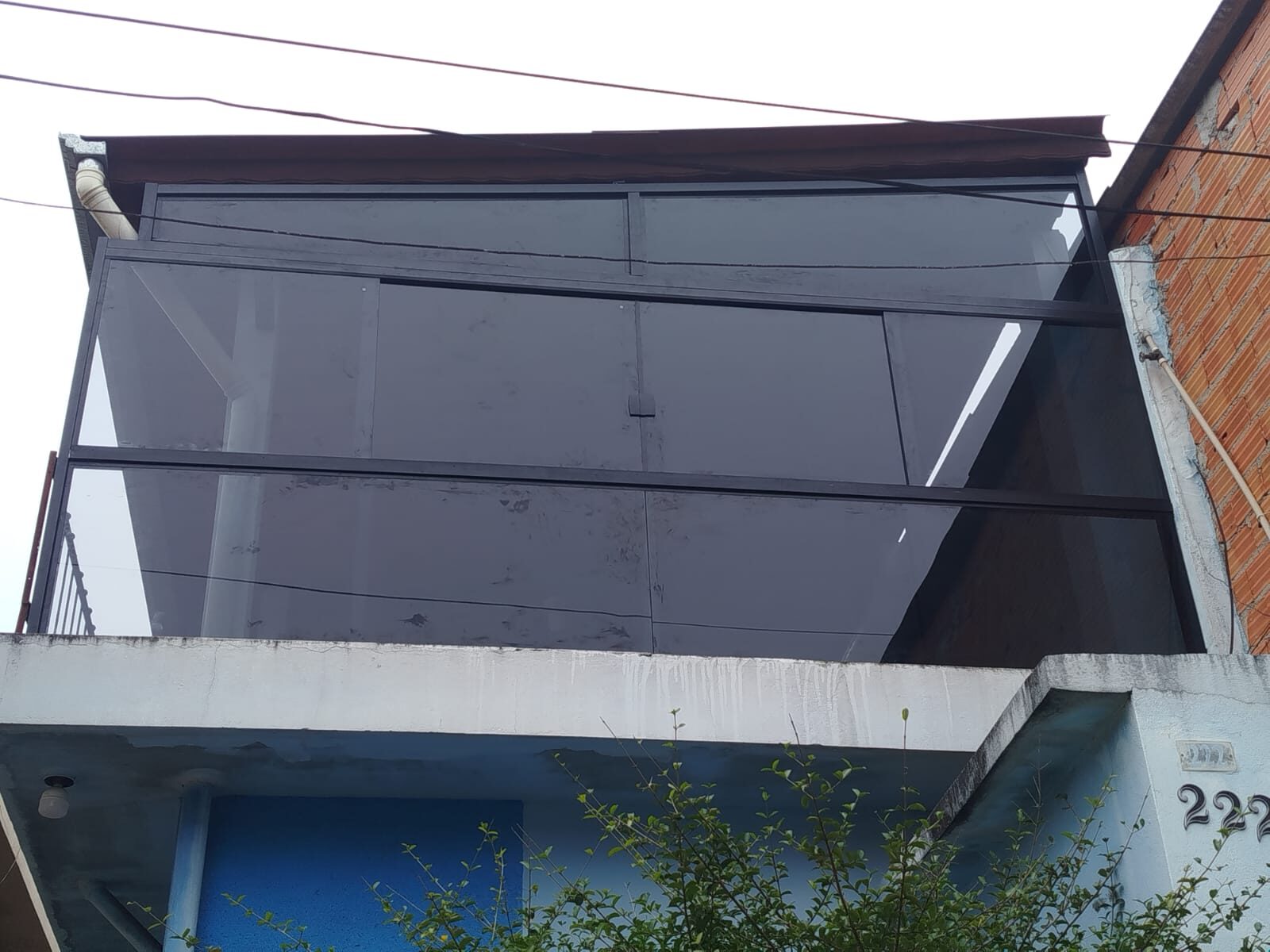 Cobertura e fechamento de vidro na fachada de sobrado