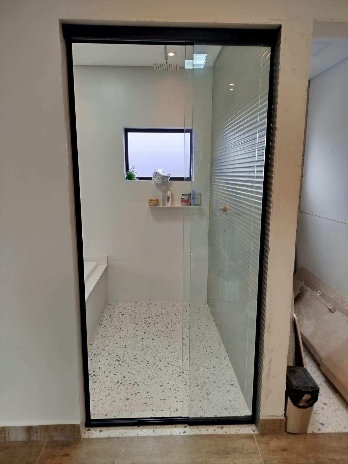 Box de vidro incolor com moldura preta em banheiro amplo